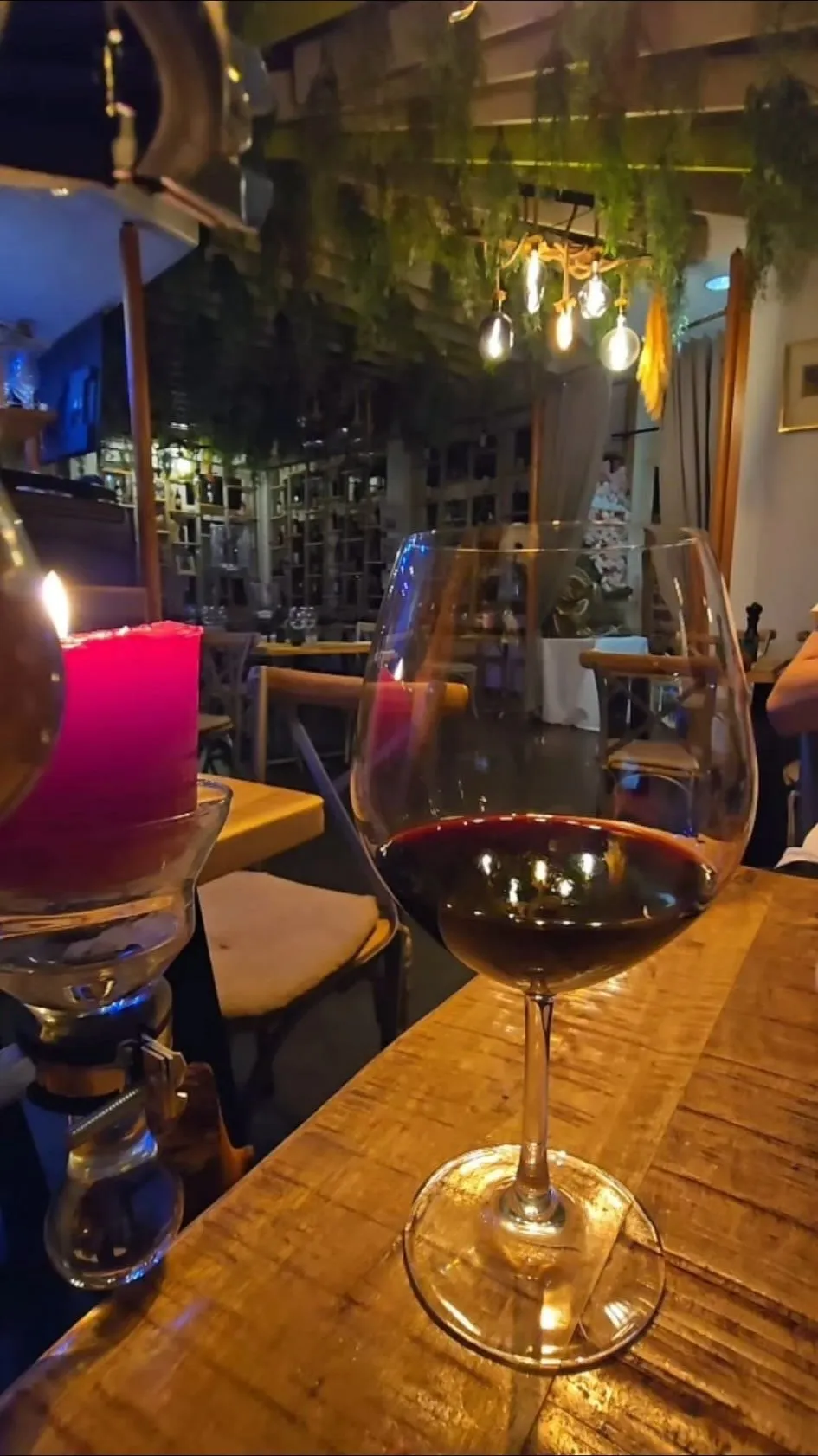 Glas Rotwein bei Kerzenlicht